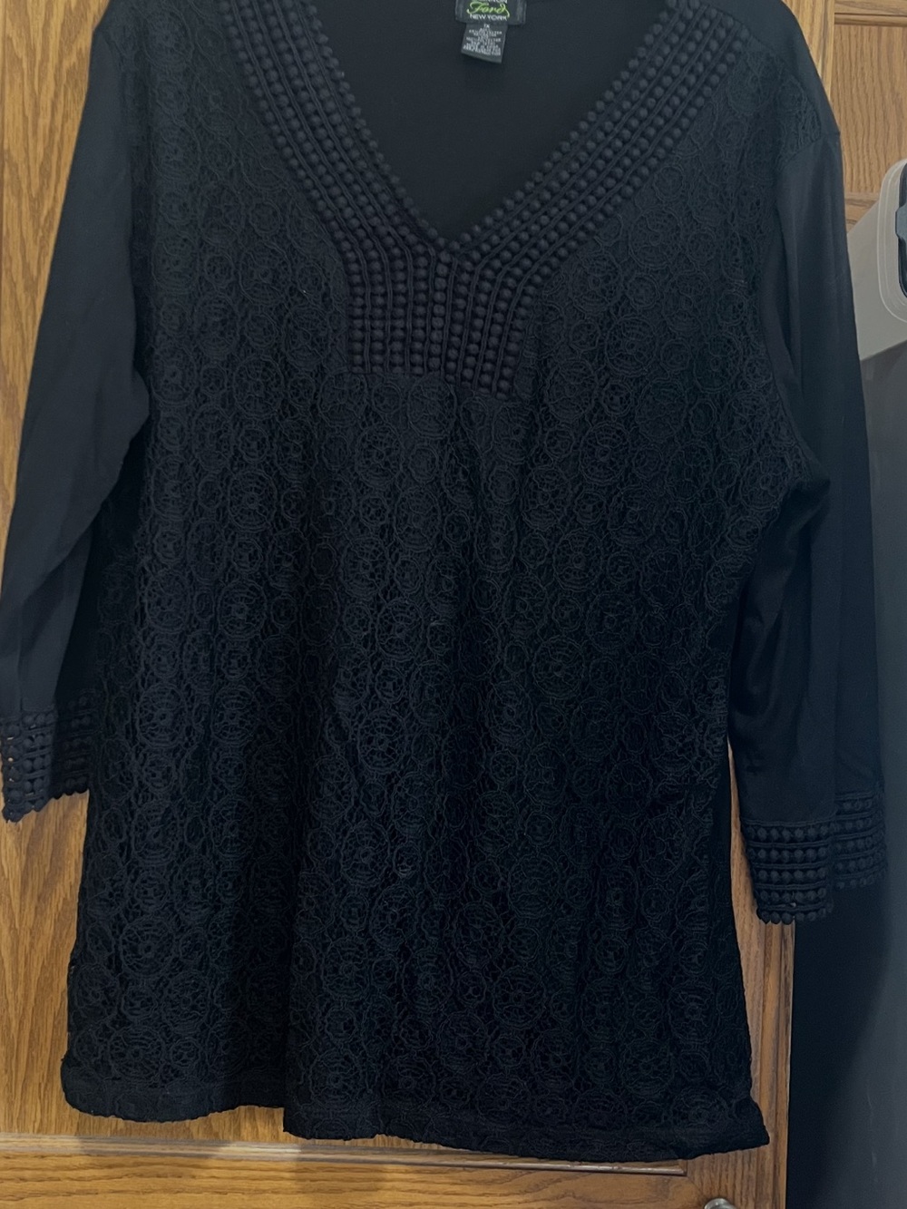 This is a Shannon Ford New York black lace blouse with a V-neck and 3/4 sleeves